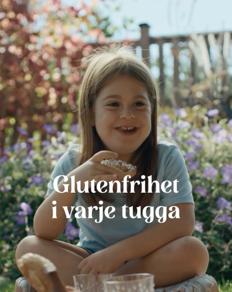 Glad tjej som äter en glutenfri kanelbulle